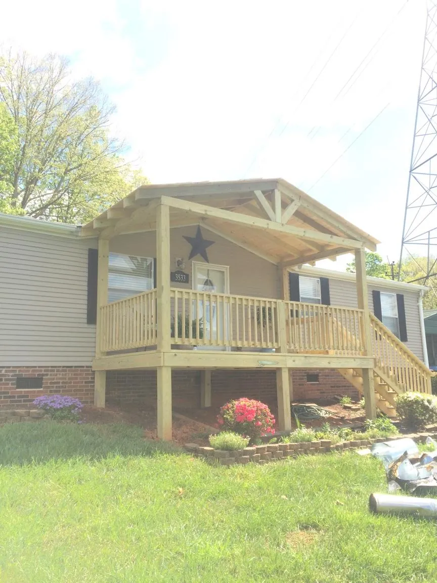 New gabled porch roof and deck railing added to a ranch home in Magnolia